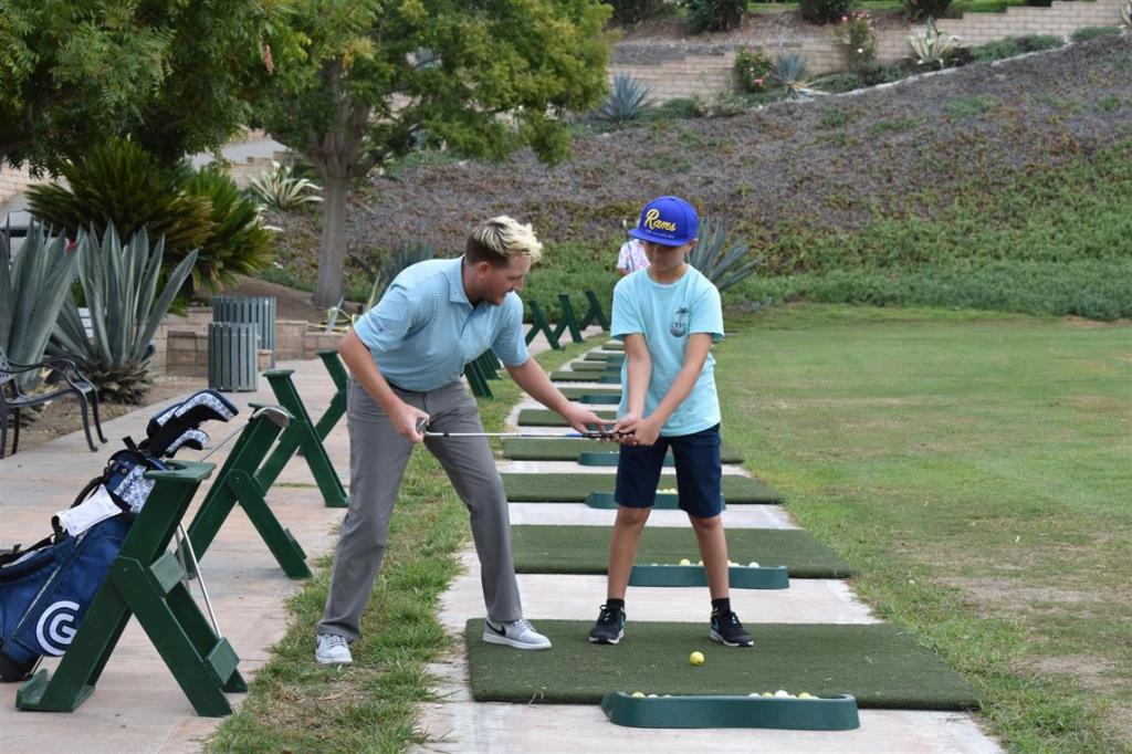 young golfer getting instruction at range