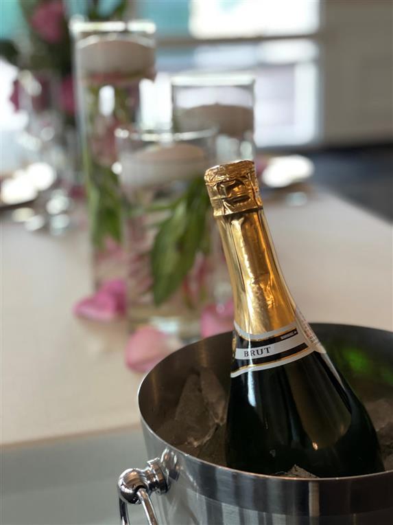 champagne bottle in ice bucket near votive candles