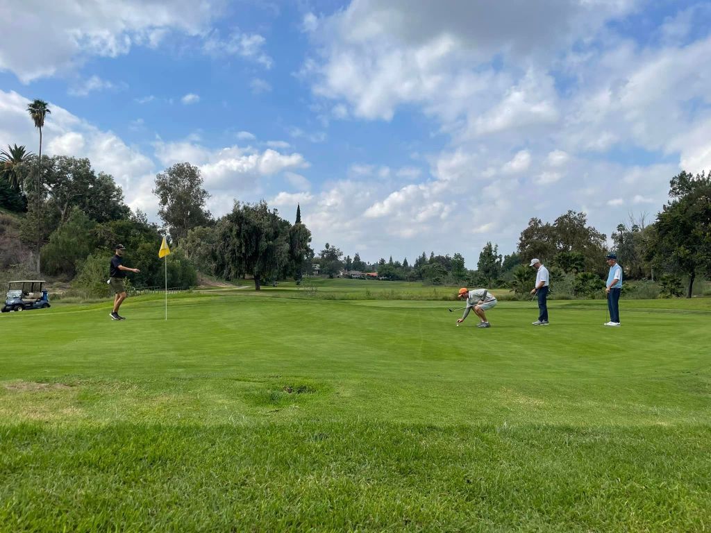 golfer on golf course setting up ball for swing 