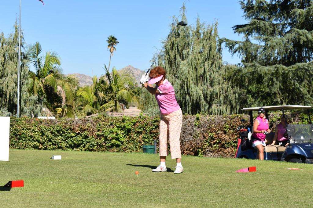 golfer in pink shirt taking a swing