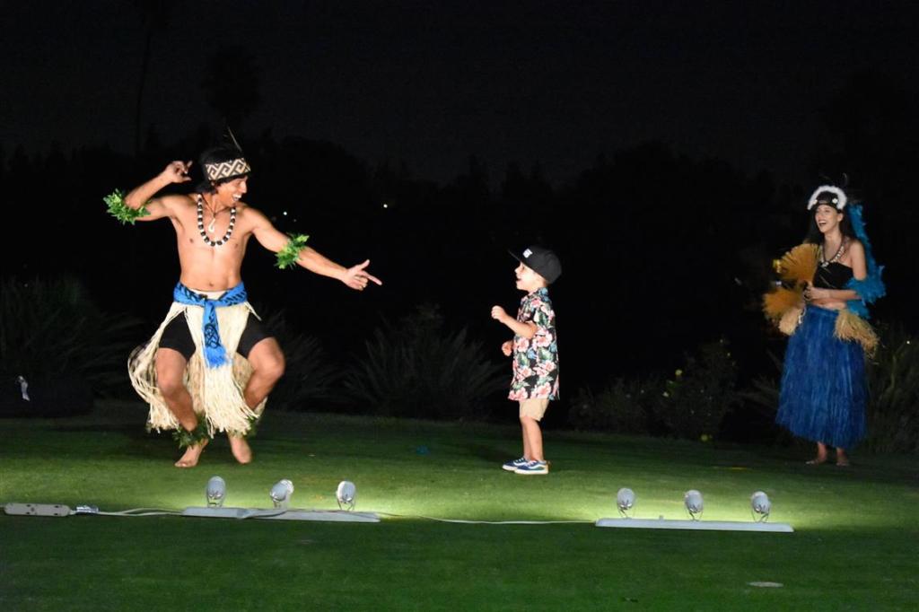 traditional dancer with guest at luau